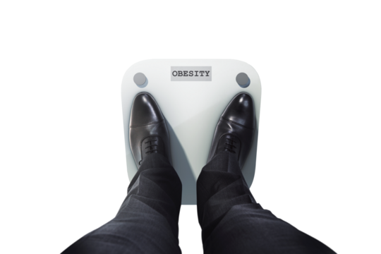 Businessman's feet in black shoes on a weight scale labeled obesity, closeup style on white background, concept of health and weight issues
