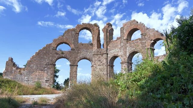 The ancient city of Aspendos. Ruins of aqueducts of Aspendos Acropolis. T&uuml;rkiye. Historical siphon of Aspendos Aqueduct with olive trees, Antalya. 4K