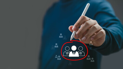 A professional person using a stylus to select team members from a digital interface, emphasizing collaborative work and team dynamics.