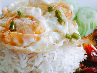 Close up of Thai basil chicken with fried egg. Thai food.