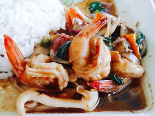 Shrimp and squid stir-fry with basil and rice, Thai food.