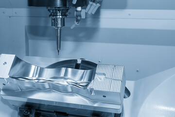 The 5 axis CNC milling machine cutting mold part by solid ball nose end mill tool in the light blue...