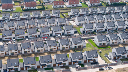 Rows of identical single-family semi-detached houses for sale &mdash; a real estate market concept highlighting new passive homes, population density, and shifting demographics.