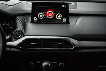 Car infotainment system's display. Close-up view of screen in car dashboard - main screen menu with access to functions like phone and radio.