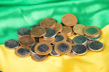 Brazilian coins displayed on national flag with green and yellow colors
