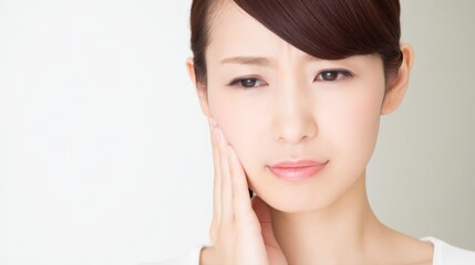 Naklejka premium A close-up of a person pressing their hand against their cheek with a pained expression, indicating acute discomfort.