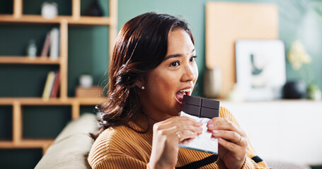 Biting, chocolate and woman with snack, home and relax in living room with tasty treat or junk...
