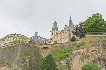 Naklejka premium Old city walls of Luxembourg and Saint Michael`s Church, low angle view from within Neumunster abbey