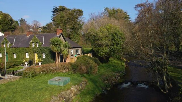 Beautiful scene showing traditional ivy covered cottage along a river stream. Rostrevor, Down, Northern Ireland