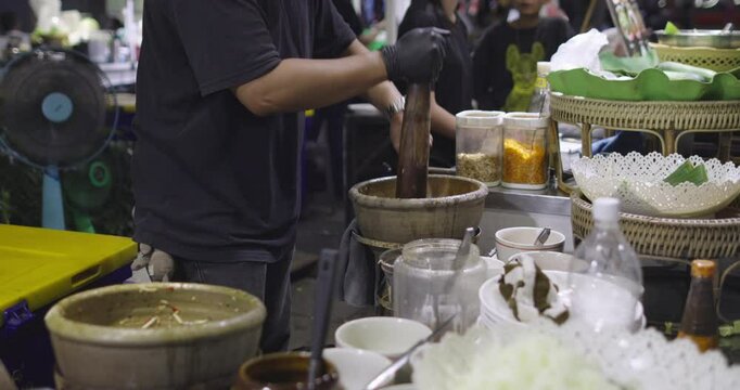 Chef Making a Som Tam or spicy green papaya salad. World-famous Thai spicy SomTum salad.