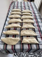 hands rolling puff pastry phyllo dough ,working process of making traditional homemade chebureki