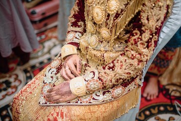 Fototapeta premium Close-up of a bride's hand adorned with intricate henna designs, symbolizing beauty and tradition in a wedding ceremony, highlighting cultural elegance and detailed body ar