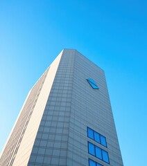 Fototapeta premium Sleek, textured modern building against a vibrant blue sky, urban landscape, skyline