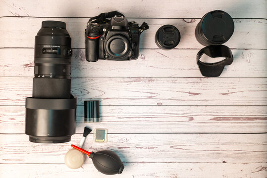 Photography equipment: digital SLR camera, lens, zoom telephoto lens and SD memory card with rustic background