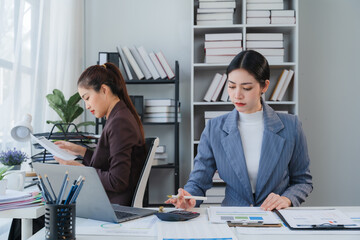 Focused Businesswomen Analyzing Data at Office Desk