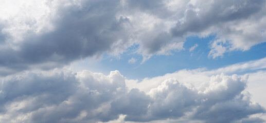 Blue sky with fluffy white close up clouds.