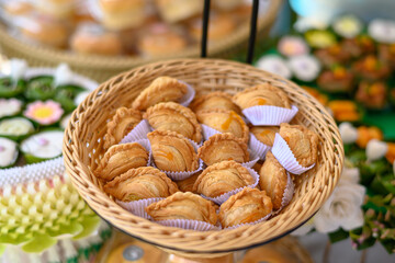 Beautiful and appetizing traditional Thai desserts including crispy curry puffs, sweet treats and jelly desserts on dessert table
