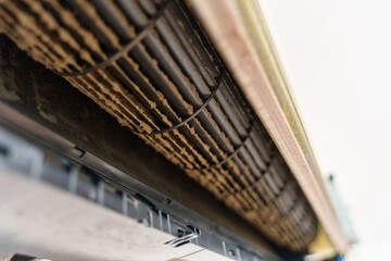 Remove and cleaning dirty air conditioner with dust covered fan blades and coils