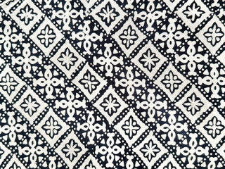 Fototapeta premium Traditional graphic background in random abstract ornamental floral and diamond pattern. Black and white ethnic lace and cloth. Seamless background texture. Indonesian batik