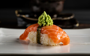 Delicious salmon nigiri sushi topped with wasabi gleaming on a white plate elegant presentation