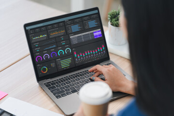 Person analyzing data on laptop with detailed dashboard report, showcasing graphs, charts, and metrics for business insights.