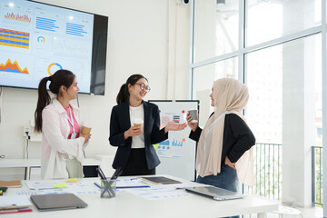 Team discussing data report with dashboard visuals in modern office, fostering collaboration and productivity