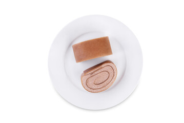 Chocolate crepe rolls with chocolate whipped cream filling in a plate on a white isolated background