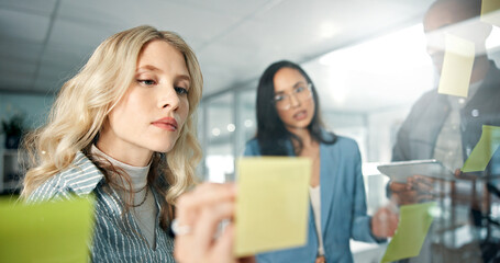 Business woman, writing and sticky note with team, brand strategist for brainstorming and market...