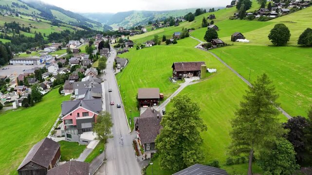 7 juli 2025, Wildhaus-Alt Sint Johann, Switzerland. Drone flight above the village centre of Wildhaus, a charming village near the Alpstein mountain range. Small alpine town centre, houses. Surrounded
