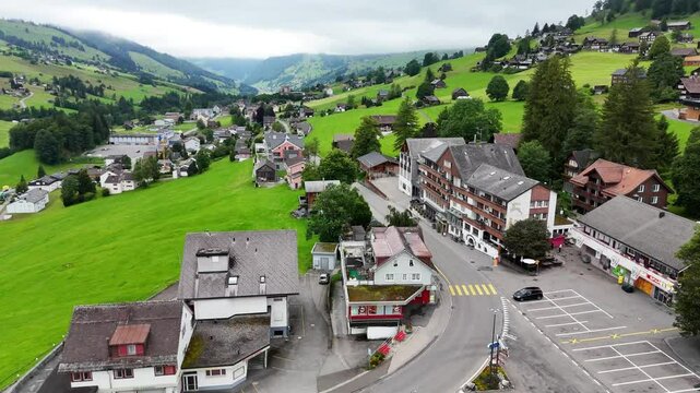 7 juli 2025, Wildhaus-Alt Sint Johann, Switzerland. Drone flight above the village centre of Wildhaus, a charming village near the Alpstein mountain range. Small alpine town centre, houses. Surrounded