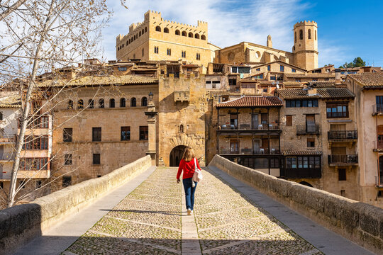 Tourist woman crossing the medieval stone bridge that leads to the town of Valderrobres, Teruel.