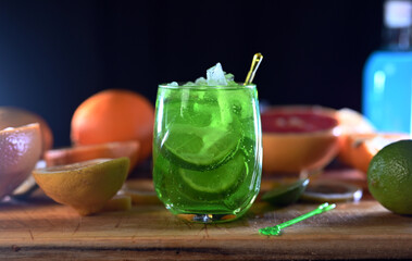 Mojito cocktail with lime wedges and ice on black background