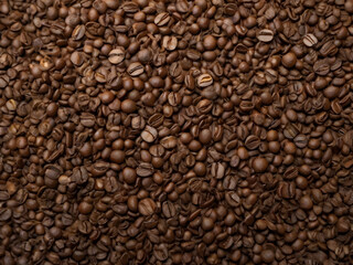 Fototapeta premium Roasted Coffee Beans Texture: Rich, dark roasted coffee beans fill the frame, creating a captivating texture perfect for backgrounds or design elements.
