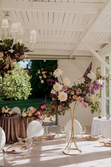 There is a long table elegantly set up, adorned with a beautiful vase filled with vibrant flowers placed on its surface