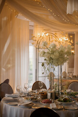 A beautifully arranged table set for a wedding reception, adorned with elegant plates, sparkling glasses, and colorful flowers on it