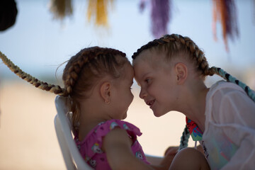 holding braids with pink color on little kid head. stylist applying braiding hair on young baby.