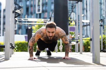 a man trains on the street with exercise machines