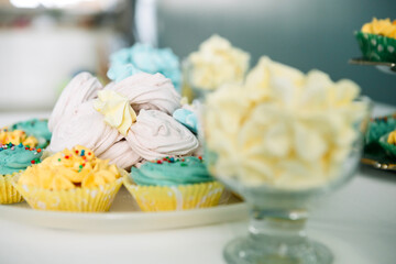 Festive bright cupcakes and cakes on the table, Side view.
