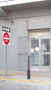 Letrero de "No entre y tr&aacute;nsito" en una calle. Cerca hay un edificio con una parta que tiene un port&oacute;n de seguridad.La foto fue tomada de d&iacute;a y en Bayam&oacute;n, Puerto Rico