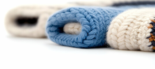 Macro Shot of Rolled Knitted Scarves with Blue and Cream Stripes on White Seamless Background in Studio Lighting