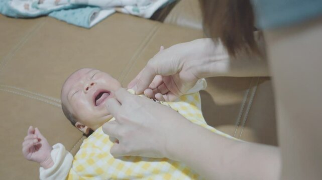 A precious moment capturing a baby crying while being gently held and comforted. The scene highlights the bond and connection between the caregiver and the infant, showcasing the emotional depth of ea