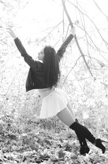 Close-up portrait of a fantastic young model girl posing in the park on a sunny day. Black and white photo.