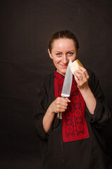 A woman is cutting smoked meat into the kitchen.