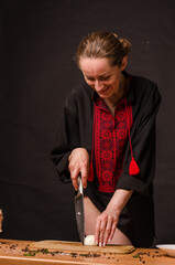 Girl's hand with a knife cutting onions on wooden Board