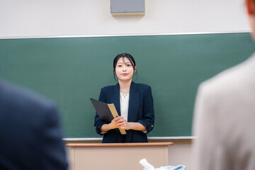 学校で教壇に立って授業をする若い女性教師