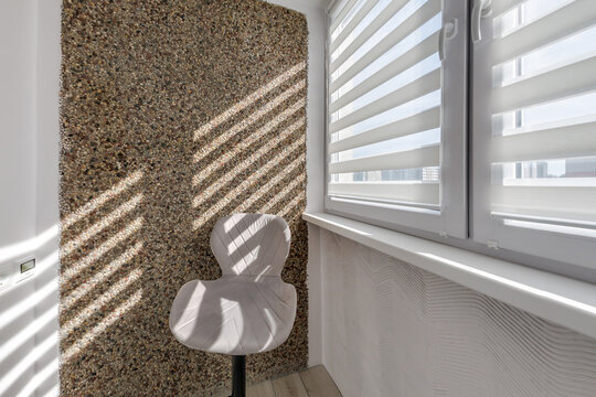 Modern double roller zebra blinds on large windows in bright minimalist interior with sunlight streaming through on balcony