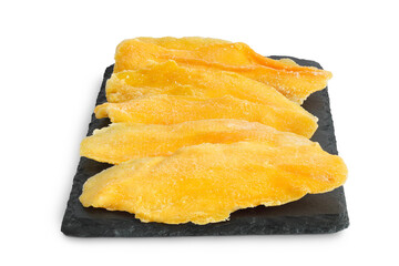 dried mango on a black stone board isolated on white background