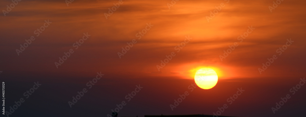 Wall mural sun against the background of red clouds.