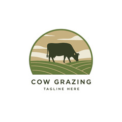 Obraz premium Cow Grazing in a Green Field Logo