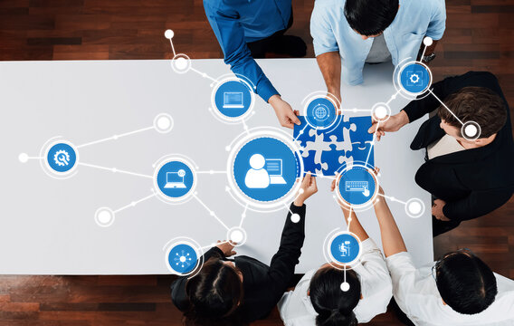 A dynamic scene showcasing a diverse group of professionals collaborating over a puzzle piece, symbolizing teamwork and digital connections in a modern business setting. Amity